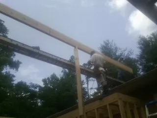 Carpenter setting a ridge beam over a new addition frame — Ice Dam Removal by Roofing Brothers in Williams