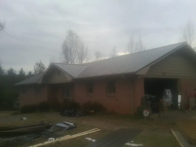 Gray metal roof on a stucco house with an attached garage in Williams